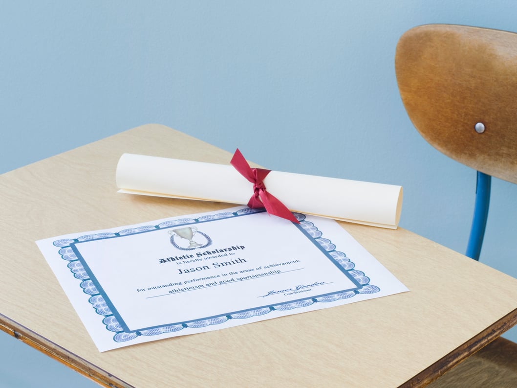 Diploma and certificate of achievement on school desk